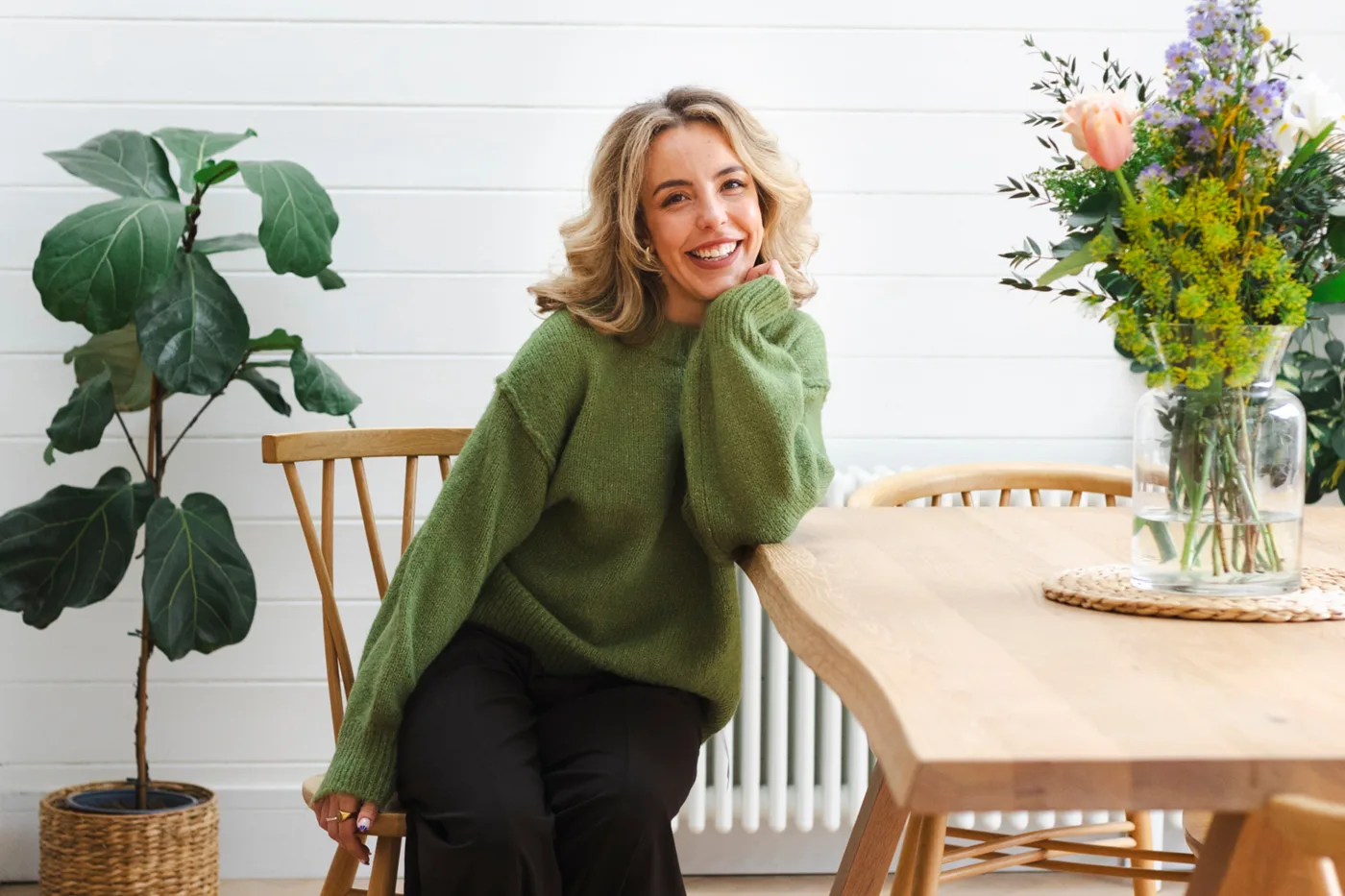 Cailin Lambrechts, founder of Serene and Solace, sitting at a wooden table