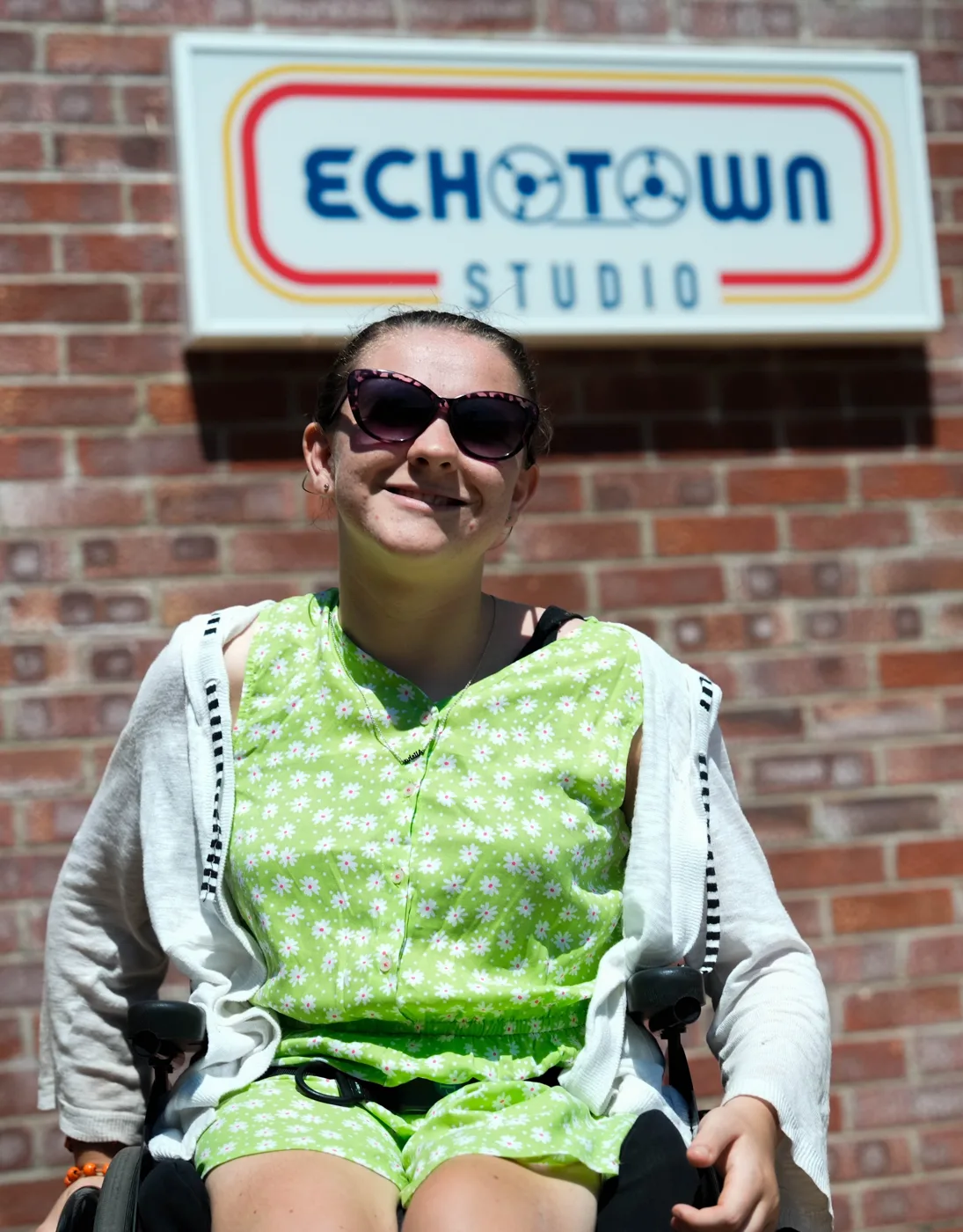 Alisha outside Echotown Studio in Dorchester, under the studio sign