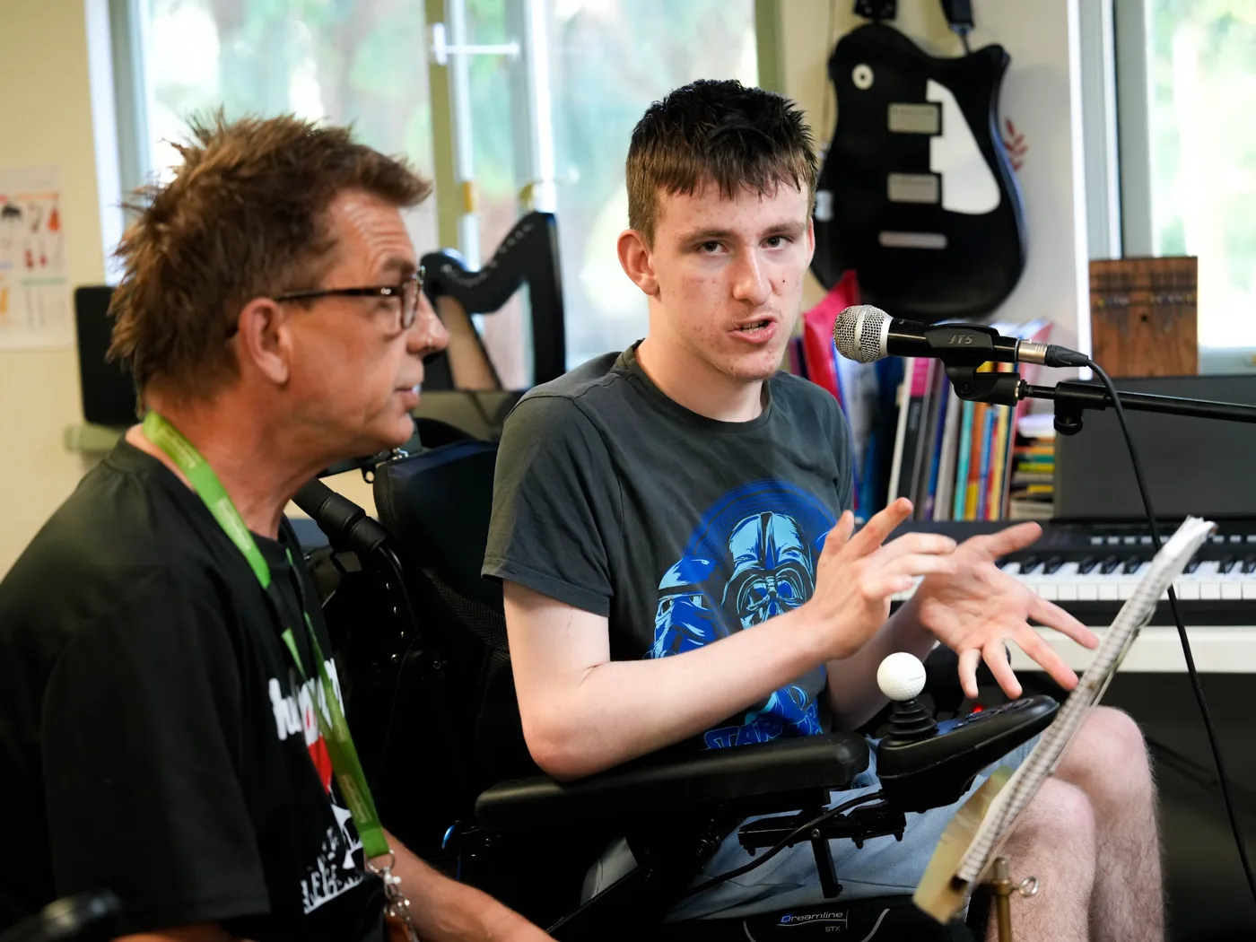 Student Stanley at a microphone beside staff member Mike
