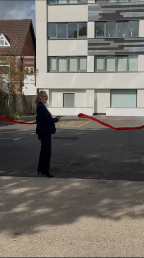 The Mayor of Poole holding scissors beside a cut red ribbon in the Altitude car park